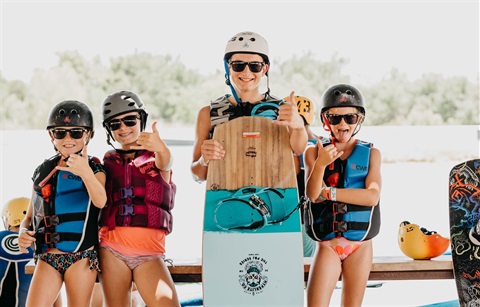 Kids standing in a line with wake boards at Hydrous Wake Park