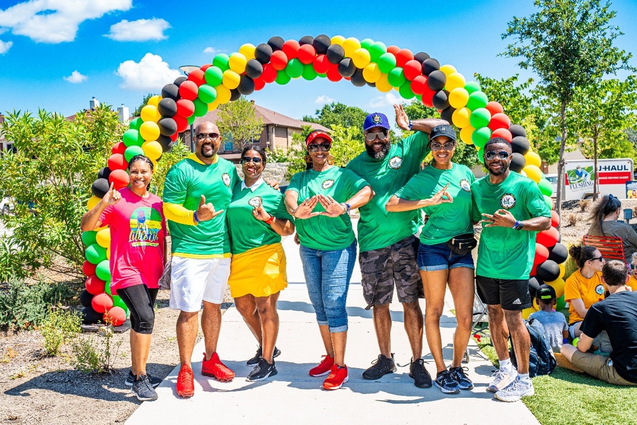 Group of people posing in front of Juneteenth balloons